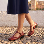 Azucena: bailarinas mary jane cuadradas, color rojo, puestos en los pies sobre empedrado de Granada