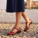 Azucena: bailarinas mary jane cuadradas, color rojo, puestos en los pies sobre empedrado de Granada