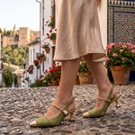 Cayetana: zapatos destalonados con perla, color verde, puestos en los pies sobre empedrado de Granada