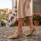 Cayetana: zapatos destalonados con perla, color verde, puestos en los pies sobre empedrado de Granada