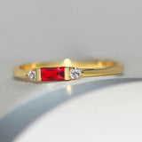 Piedra roja central con anillo dorado y brillante