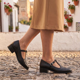 Susana: zapatos tira en t brogue, color negro, puestos en los pies sobre empedrado de Granada