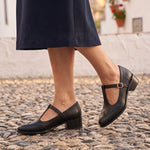 Virginia: zapatos tira en t vintage, color negro, puestos en los pies sobre empedrado de Granada