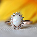 Anillo vintage en oro rosa con ópalo ovalado y borde de cristal radiante