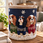 Cesta acolchada Rey Carlos con tres perritos, sobre una mesa de madera junto a la ventana